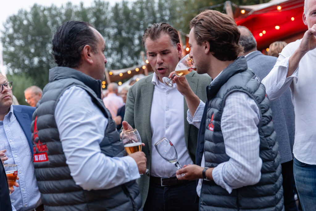Deelnemers proeven samen van een glas wijn tijdens het aperitief van 2024